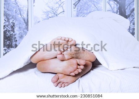 Affectionate of couple sleeping on the bedroom looks from their feet, shot in winter day