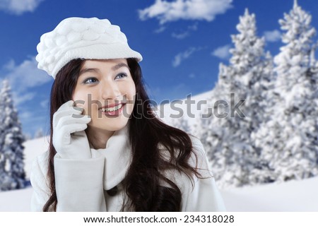 Lovely face of young girl smiling while wearing winter wear and hat, shot outdoors