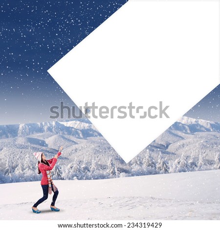 Young girl with a winter knitted clothes pull an empty board for copy space on the mountain