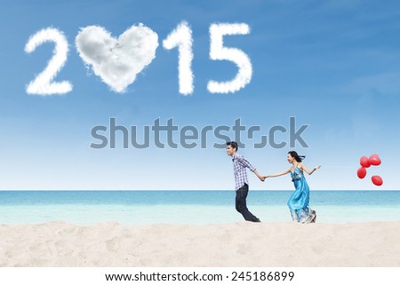 Asian lovers holding hands and run together on beach enjoy new year holiday
