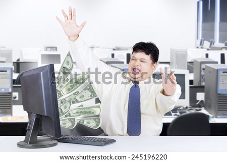 Successful businessman get money from internet while working in the office