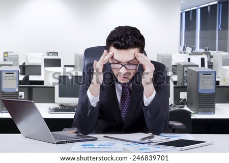 Caucasian businessman working in the office and feel headache