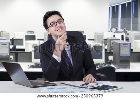 Portrait of young businessman imagine his idea while smiling happy at the workplace