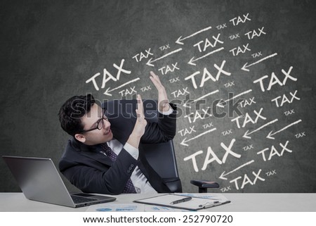 Worried entrepreneur working with laptop on the table and get pressure to pay tax