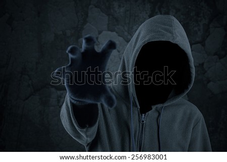 Mysterious robber try to grab something with his hand and looks scary