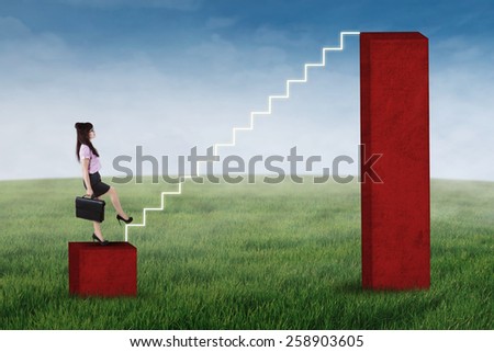 Businesswoman stepping up on the stair of business graph