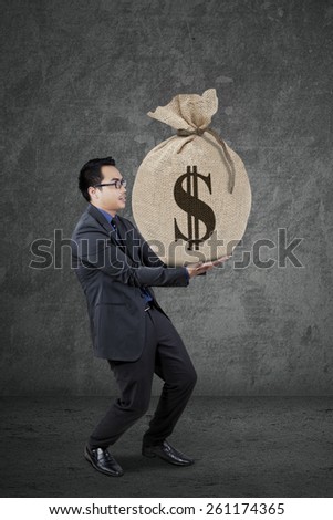 Young businessman wearing formal suit and carry a money sack