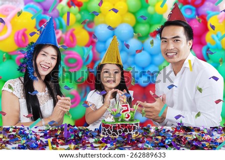 Portrait of happy family singing while clapping hands together in birthday party