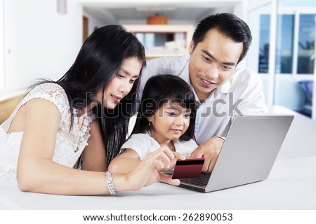Modern family using a laptop computer and credit card to online shopping at home