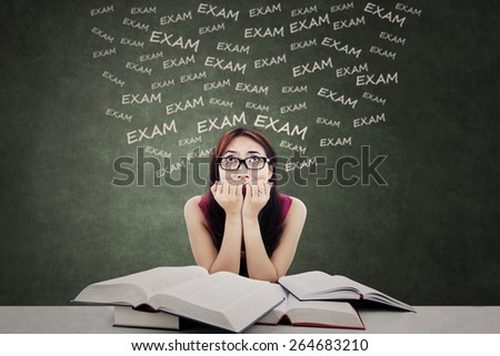 Portrait of female student biting her nail and feel nervous to face exam