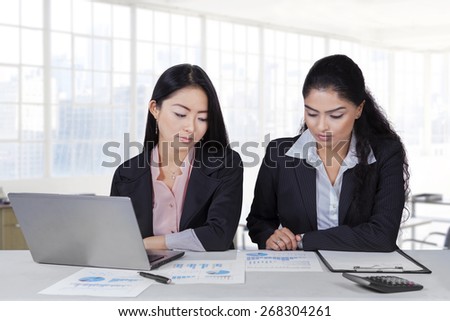 Young businesswomen sitting in the office while doing their job with paperwork and laptop
