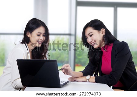 Two beautiful businesswoman office worker discussing in the office