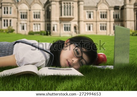 Female college student sleeping on the grass at campus