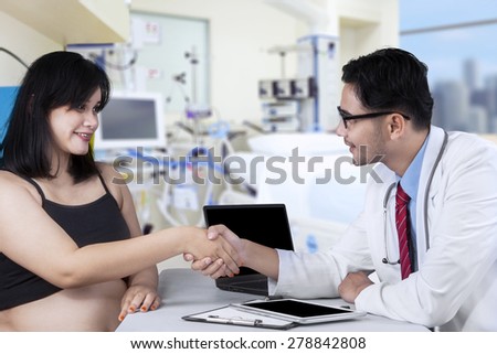 Portrait of asian pregnant woman handshaking with doctor in hospital