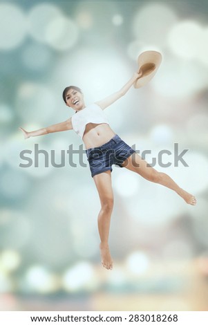 Attractive young woman enjoy holiday and jumps over light glitter background