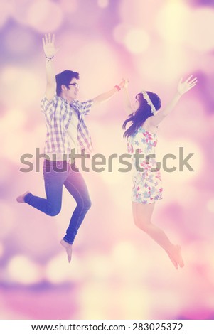 Portrait of joyful couple enjoy freedom and jumping together, shot with festive blur background