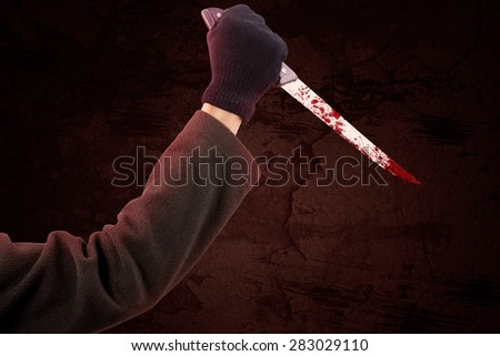 Closeup of hand using a sharp and bloody knife to stab and wounded