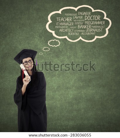 Beautiful young bachelor imagine her future jobs after finishing her study while wearing graduation gown
