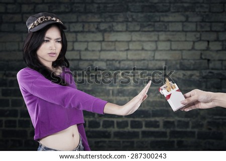 Portrait of teenage girl rejecting to take cigarette and refuse to smoke