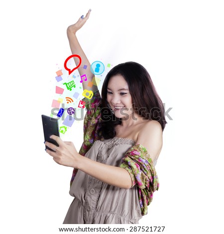 Happy teenage girl with casual clothes using cellphone to use social media, shot in the studio