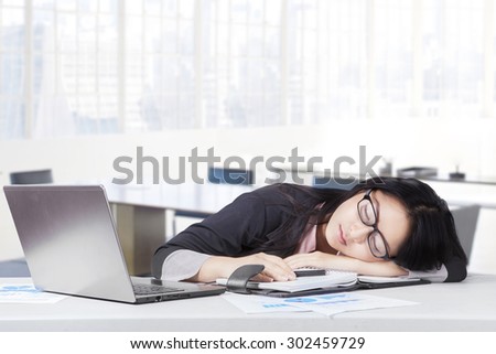 Portrait of female worker wearing formal suit relaxing and sleeping in office with laptop in office