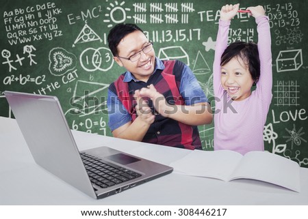 Portrait of happy female student celebrating her success in the classroom with her teacher gives clapping hands