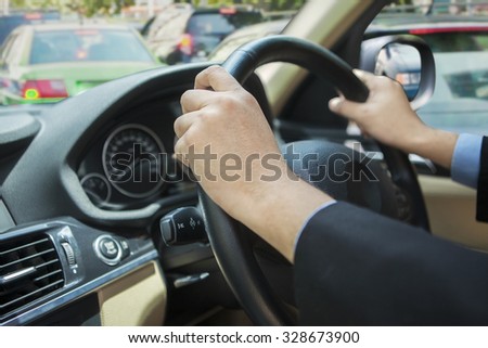 Photo of worker hands holding steer and driving the car in the traffic jam