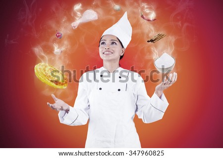 Portrait of indian female chef wearing uniform and cooking like a juggler