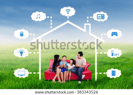 Portrait of joyful family having fun together on the sofa under a design of smart home technology system
