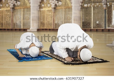 Picture of Asian family wearing Islamic clothes while posing prostration in the mosque