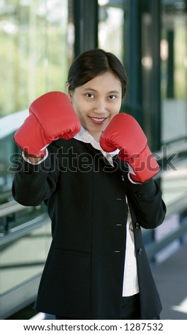 Businesswoman with boxing glove is ready to knock out competitiors