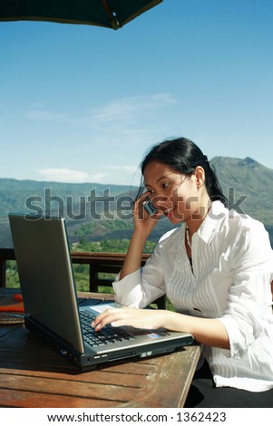 Asian woman working at a restaurant with a mountain in the background.