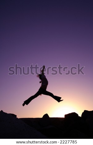 A woman jumping expressing her happiness at sunset