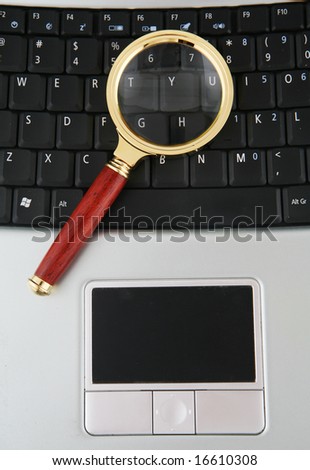 Close-up shot of laptop computer keyboard with magnifying glass