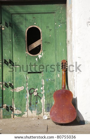 Close up shot of guitar and abandoned vintage door exterior