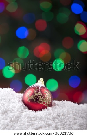 Christmas ball shot with snow and colorful background lights