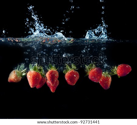 Fresh strawberries splashing in fresh water with water