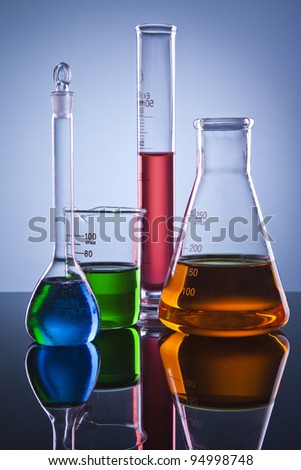Many different colored chemical solutions in laboratory glasses