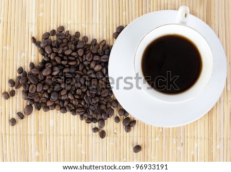 Coffee beans and a cup of coffee isolated over white background