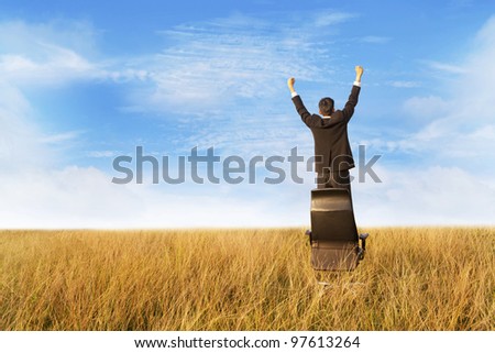 Businessman outdoor expressing his  freedom and success standing on chair