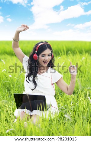 Young Asian woman listen to music enjoying summer outdoor