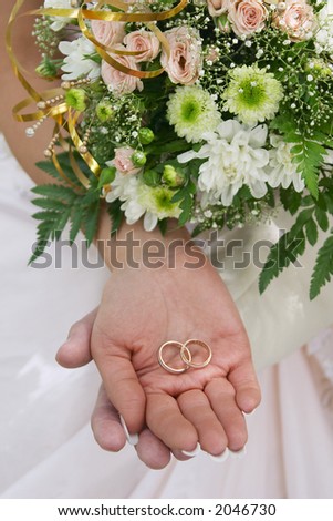 Wedding rings in hands of a newly-married couple.
