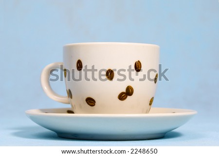 Coffee cup on saucer on a blue background. On a cup coffee grains are drawn.