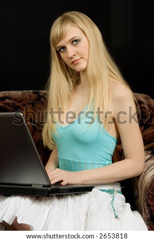 Young woman works on notebook. Black background.