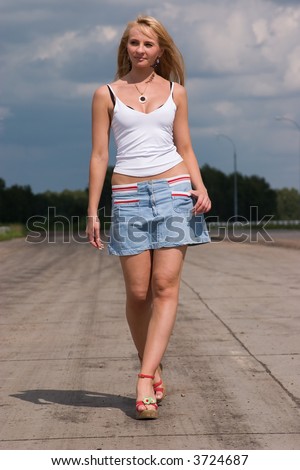 Active young woman goes on a highway.