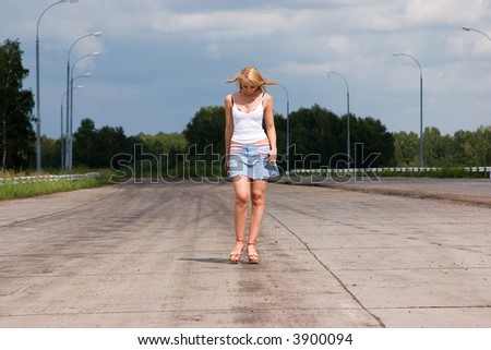 Active young woman goes on a highway.