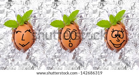 egg with funny face isolate on aluminium foil with basil