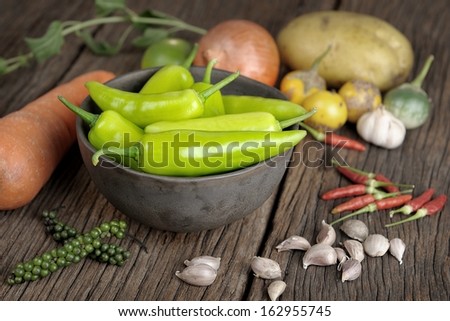 preparing ingredient for cooking on wooden table, focus on green banana pepper