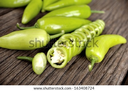 sliced green fresh banana pepper on wooden table