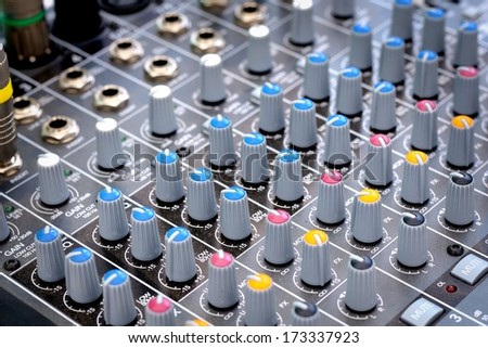 audio mixing console with faders and adjusting knobs